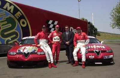 Piloti in tuta da gara accanto alle Alfa Romeo 156.